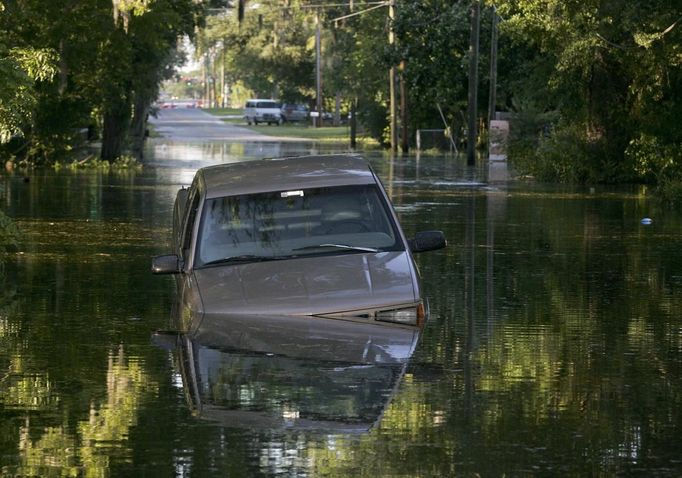 An abandoned car stuck in an underwater sinkhole sits on Houston Avenue in Live Oak, Florida, June 27, 2012. Tropical Storm Debby weakened to a tropical depression after it drifted ashore on Florida's Gulf Coast, even as it dumped more rain on flooded areas and sent thousands of people fleeing from rising rivers. REUTERS/Phil Sears (UNITED STATES - Tags: ENVIRONMENT DISASTER) Published: Čer. 28, 2012, 2:46 dop.