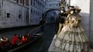 Marco Dilauro and his wife Nadia, wearing costumes, pose at a canal with the Bridge of Sighs in the background during the Venice Carnival January 25, 2013. Marco Dilauro, 43, is a tax collector by day, but his real passion is making masks and costumes for the carnival. A resident of Como, northern Italy, he chooses fabrics, ribbons, lace and costume jewellery to make the period costumes after doing extensive research, and wears them at Carnival, which ends on the day before Ash Wednesday. Picture taken January 25, 2013. REUTERS/Alessandro Bianchi (ITALY - Tags: SOCIETY) Published: Led. 28, 2013, 1:27 dop.