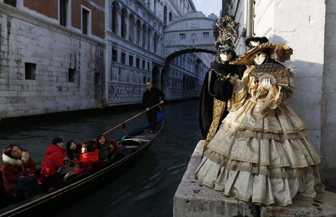 Marco Dilauro and his wife Nadia, wearing costumes, pose at a canal with the Bridge of Sighs in the background during the Venice Carnival January 25, 2013. Marco Dilauro, 43, is a tax collector by day, but his real passion is making masks and costumes for the carnival. A resident of Como, northern Italy, he chooses fabrics, ribbons, lace and costume jewellery to make the period costumes after doing extensive research, and wears them at Carnival, which ends on the day before Ash Wednesday. Picture taken January 25, 2013. REUTERS/Alessandro Bianchi (ITALY - Tags: SOCIETY) Published: Led. 28, 2013, 1:27 dop.