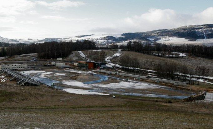 Pohled na celý stadion prostoru startu a cíle. Při porovnání s okolními horami je patrné, že poloha o několik stovek metrů výše by lyžařskému areálu jednoznačně pomohla.