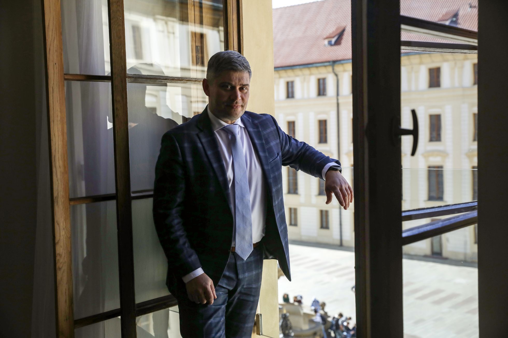 Tomáš Lebeda se dívá ze své kanceláře přímo na jedno z nádvoří Pražského Hradu. V této chvíli se opírá rukou jen o téměř neviditelné skleněné zábradlí.