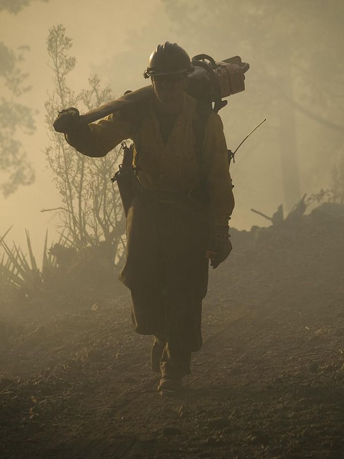 A firefighter carries a chain saw during wildfires in the Gila National Forest, New Mexico, in this handout photo made available on June 4, 2012. Firefighters battling New Mexico's largest-ever blaze gained ground on Sunday and officials said they would begin to allow evacuated residents to return home on Monday. REUTERS/Kari Greer/InciWeb/United States Forest Service/Handout (UNITED STATES - Tags: ENVIRONMENT DISASTER) FOR EDITORIAL USE ONLY. NOT FOR SALE FOR MARKETING OR ADVERTISING CAMPAIGNS. THIS IMAGE HAS BEEN SUPPLIED BY A THIRD PARTY. IT IS DISTRIBUTED, EXACTLY AS RECEIVED BY REUTERS, AS A SERVICE TO CLIENTS Published: Čer. 5, 2012, 12:30 dop.