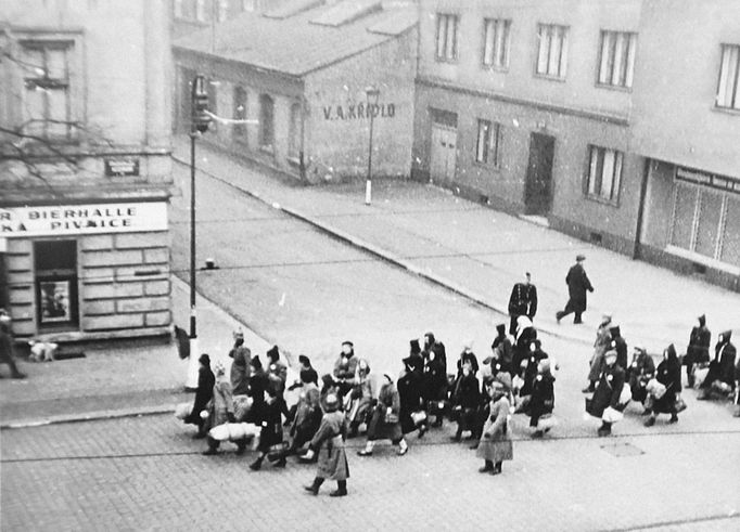 Snímek zachycující jdoucí židovský transport křižovatkou U Smaltovny nedaleko nádraží Praha Bubny v Praze.