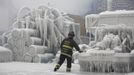 Chicago Fire Department Lieutenant Charley De Jesus walks around an ice-covered warehouse that caught fire Tuesday night in Chicago January 23, 2013. Fire department officials said it is the biggest fire the department has had to battle in years and one-third of all Chicago firefighters were on the scene at one point or another trying to put out the flames. An Arctic blast continues to gripped the U.S. Midwest and Northeast Wednesday, with at least three deaths linked to the frigid weather, and fierce winds made some locations feel as cold as 50 degrees below zero Fahrenheit. (minus 46 degrees Celsius) REUTERS/John Gress (UNITED STATES - Tags: DISASTER ENVIRONMENT) Published: Led. 23, 2013, 5:42 odp.