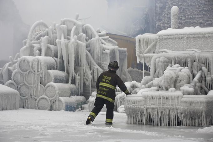 Chicago Fire Department Lieutenant Charley De Jesus walks around an ice-covered warehouse that caught fire Tuesday night in Chicago January 23, 2013. Fire department officials said it is the biggest fire the department has had to battle in years and one-third of all Chicago firefighters were on the scene at one point or another trying to put out the flames. An Arctic blast continues to gripped the U.S. Midwest and Northeast Wednesday, with at least three deaths linked to the frigid weather, and fierce winds made some locations feel as cold as 50 degrees below zero Fahrenheit. (minus 46 degrees Celsius) REUTERS/John Gress (UNITED STATES - Tags: DISASTER ENVIRONMENT) Published: Led. 23, 2013, 5:42 odp.