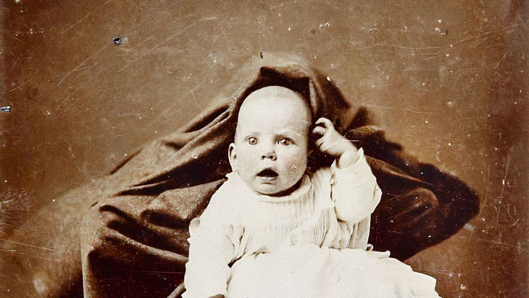Snímek, na kterém je zobrazeno dětí spolu se zamaskovanou matkou. Nedatovaná fotografie z Viktoriánské éry.