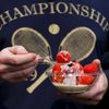 A spectator eats strawberries and cream at the Wimbledon Ten