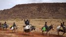 A farmer waves while riding a donkey with his family near Douentza January 28, 2013. REUTERS/Joe Penney (MALI - Tags: CIVIL UNREST POLITICS CONFLICT SOCIETY) Published: Led. 28, 2013, 8:39 odp.