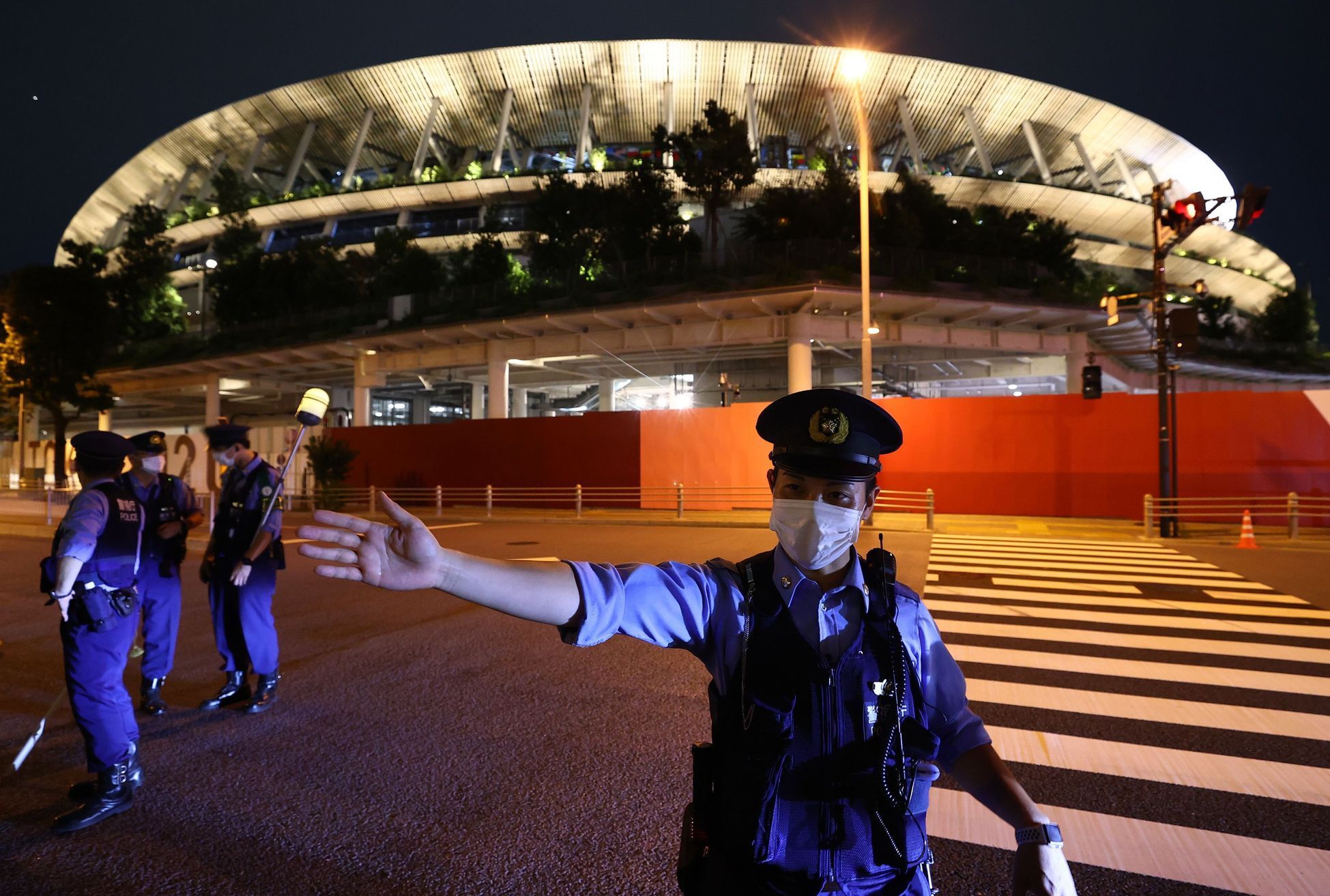Policista při slavnostním zahájení před stadionem v Tokiu