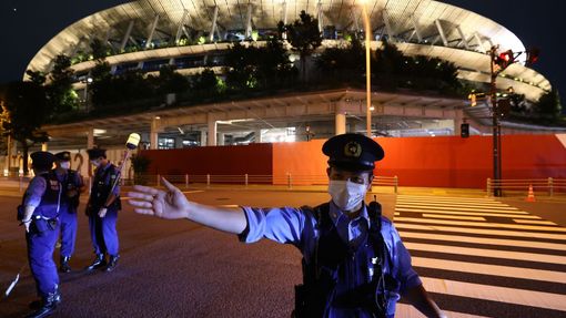 Policista při slavnostním zahájení před stadionem v Tokiu