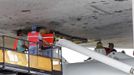 Space center workers work to attach space shuttle Discovery to a NASA 747 aircraft in the Mate Demate facility at Kennedy Space Center in Cape Canaveral