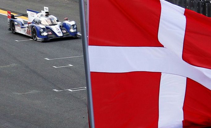 Kazuki Nakajima of Japan drives his Toyota TS 030 Hybrid Number 7 as a Danish flag is flown at half-mast during the Le Mans 24-hour sportscar race in Le Mans, central Fra