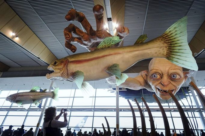 A woman takes a photo of a giant sculpture of J. R. R. Tolkien character Gollum at Wellington International Airport November 27, 2012. New Zealand's capital city was rushing to complete its transformation into a haven for hairy feet and pointed ears on Tuesday as stars jetted in for the long-awaited world premiere of the first movie of the Hobbit trilogy. REUTERS/Mark Coote (NEW ZEALAND - Tags: ENTERTAINMENT TRANSPORT) Published: Lis. 27, 2012, 3:01 dop.