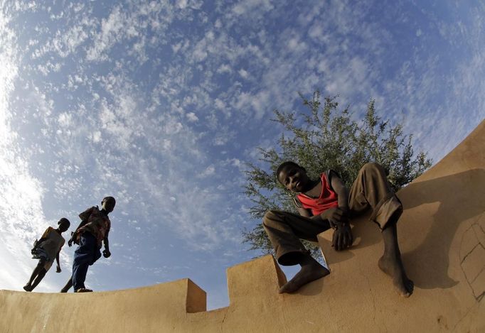 Children hang out on top of a wall in a refugee camp in Sevare January 26, 2013. REUTERS/Eric Gaillard (MALI - Tags: CIVIL UNREST CONFLICT POLITICS) Published: Led. 26, 2013, 6:25 odp.