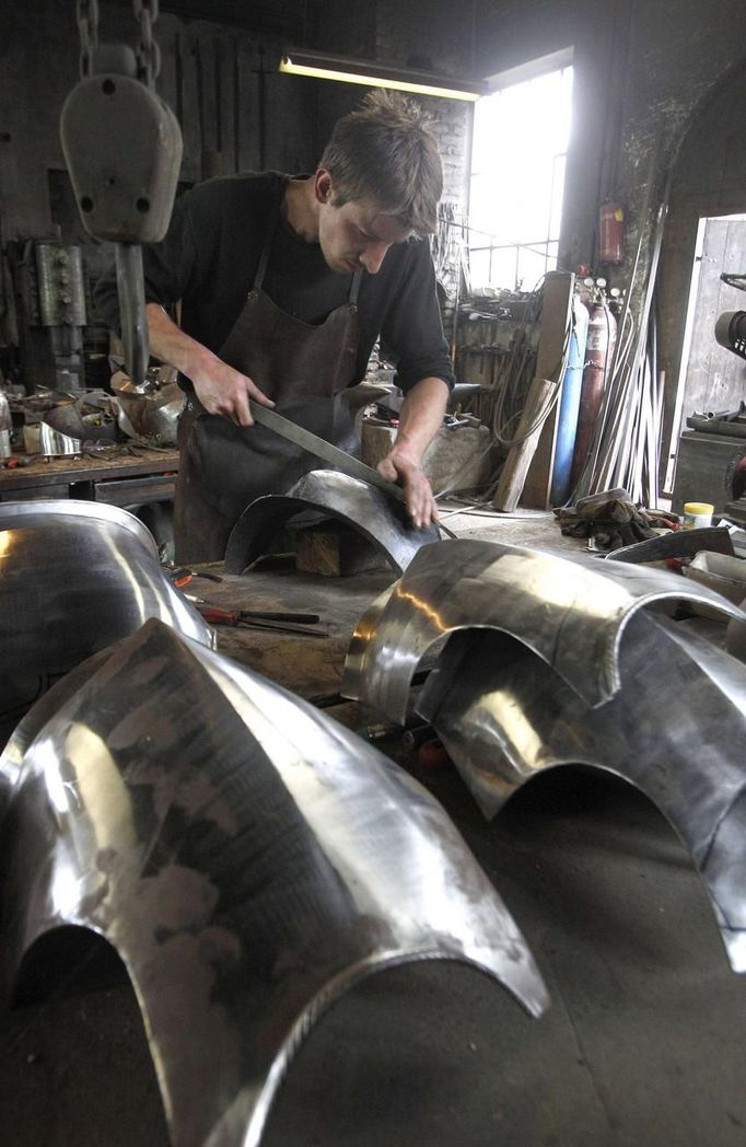 Blacksmith Johann Schmidberger works on a harness for the Vatican Swiss Guard at his workshop in Molln, Upper Austria June 12, 2012. Blacksmith brothers Johann, 29, and Georg, 28, produce made-to-order handmade harnesses for the Vatican, which take 120 hours of handiwork per piece and hardly differs from the 500-year-old originals. The brothers carry on the tradition of the blacksmith trade in the fifth generation of their family. REUTERS/Lisi Niesner (AUSTRIA - Tags: SOCIETY MILITARY) Published: Čer. 12, 2012, 9:55 odp.