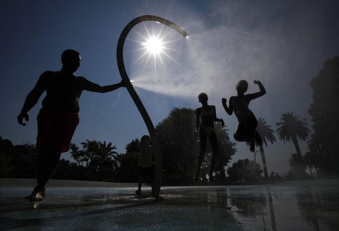 Children play under a shower in a public garden to cool off in the summer heat in Nice August 18, 2012. The French local authorities have warned of a heat wave during the weekend. REUTERS/Eric Gaillard (FRANCE - Tags: ENVIRONMENT SOCIETY TPX IMAGES OF THE DAY) Published: Srp. 18, 2012, 3:53 odp.