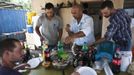 Nadav (C), the chief cowboy of the Yonatan herd, and his team eat at the end of the day after selling their cattle, just outside Moshav Yonatan, a collective farming community, about 2 km (1 mile) south of the ceasefire line between Israel and Syria in the Golan Heights May 21, 2013. Cowboys, who have been running the ranch on the Golan's volcanic rocky plateau for some 35 years, also host the Israeli military, who use half of the cattle farm, 20,000 dunams (5,000 acres), as a live-fire training zone. Israel captured the Golan Heights from Syria in the 1967 Middle East war and annexed the territory in 1981, a move not recognized internationally. Picture taken May 21, 2013. REUTERS/Nir Elias (ENVIRONMENT ANIMALS SOCIETY) ATTENTION EDITORS: PICTURE 23 OF 27 FOR PACKAGE 'COWBOYS OF THE GOLAN HEIGHTS' SEARCH 'COWBOY GOLAN' FOR ALL IMAGES Published: Kvě. 29, 2013, 10:08 dop.