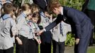 Britain's Prince Harry looks at a girl's badges as he meets school children during his official welcome at Government House in Wellington