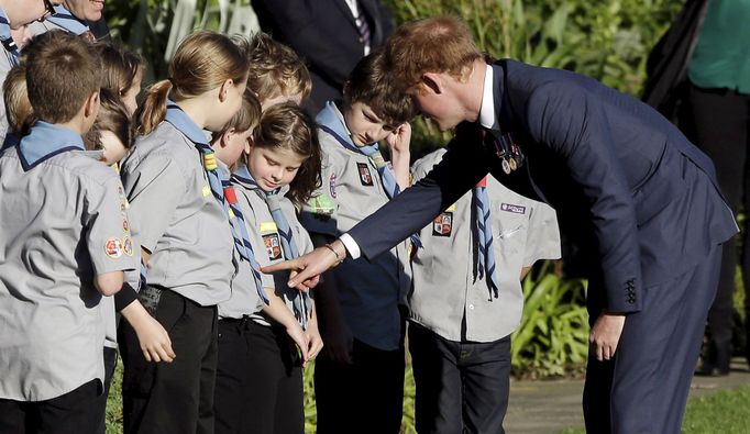 Britain's Prince Harry looks at a girl's badges as he meets school children during his official welcome at Government House in Wellington