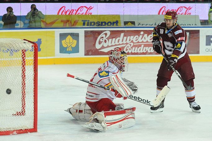 Hokejista pražské Sparty Ivan Rachůnek střílí gól za záda Šimona Hrubce v utkání 6. kola Tipsport extraligy 2012/13 s Oceláři Třinec.