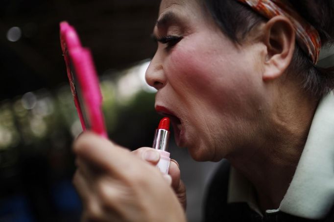 Xiao Cao, a 57-year-old gay man, puts on makeup before his performance at a park in Shanghai April 8, 2012. China's gay community has long been on the edges of society but it is gradually becoming more accepted. Cao, who is an unemployed drag queen, is one whose life lifts the curtain on a less romanticised view of Chinese homosexuals. Living in an eight-square-metre apartment behind a public toilet and with a monthly income of 500 yuan ($79) from social insurance, he passes his days dancing in public and spending time with friends at gay clubs. Picture taken April 8, 2012. REUTERS/Aly Song (CHINA - Tags: SOCIETY) CHINA OUT. NO COMMERCIAL OR EDITORIAL SALES IN CHINA. ATTENTION EDITORS PICTURE 09 OF 28 OF PACKAGE 'GAY AND OUT IN CHINA' TO FIND ALL IMAGES SEARCH 'GAY OUT CHINA' Published: Čer. 1, 2012, 12:36 dop.