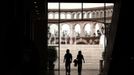 A man and a woman walk through a building that resembles a Roman Coliseum at the Florentia Village in the district of Wuqing, located on the outskirts of the city of Tianjin June 13, 2012. The shopping center, which covers an area of some 200,000 square meters, was constructed on a former corn field at an estimated cost of US$220 million and copies old Italian-style architecture with Florentine arcades, a grand canal, bridges, and a Coliseum-like building. REUTERS/David Gray (CHINA - Tags: SOCIETY BUSINESS) Published: Čer. 13, 2012, 5:48 odp.