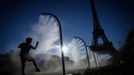 A boy plays under a spray of cooling water on a hot day outside the Eiffel Tower Stadium during the 2024 Olympics in Paris, France, July 28, 2024. REUTERS/Esa Alexander