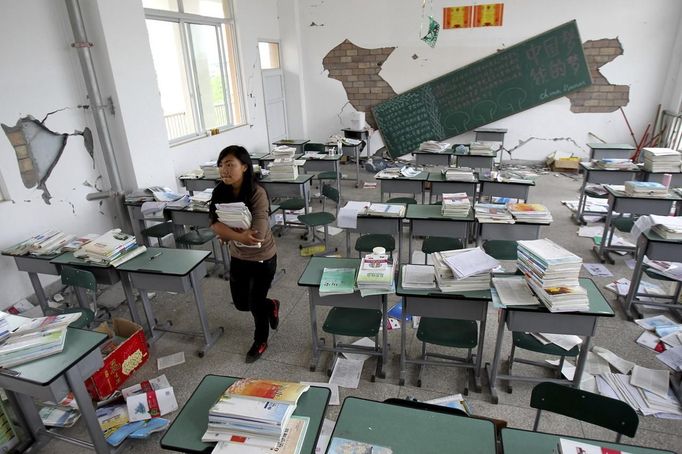 Chen Liujun carries books out of her classroom after Saturday's earthquake hit Lushan county, Ya'an, Sichuan province, April 22, 2013. Chen and her fellow third-year high school students in Lushan were transferred to Chengdu to complete their high school education and prepare for the coming college entrance exams in the provincial capital, reported local news. Hundreds of survivors of an earthquake that killed nearly 200 people in southwest China pushed into traffic on a main road on Monday, waving protest signs, demanding help and shouting at police. Picture take April 22, 2013. REUTERS/Stringer (CHINADISASTER - Tags: DISASTER EDUCATION) CHINA OUT. NO COMMERCIAL OR EDITORIAL SALES IN CHINA Published: Dub. 23, 2013, 5:09 dop.