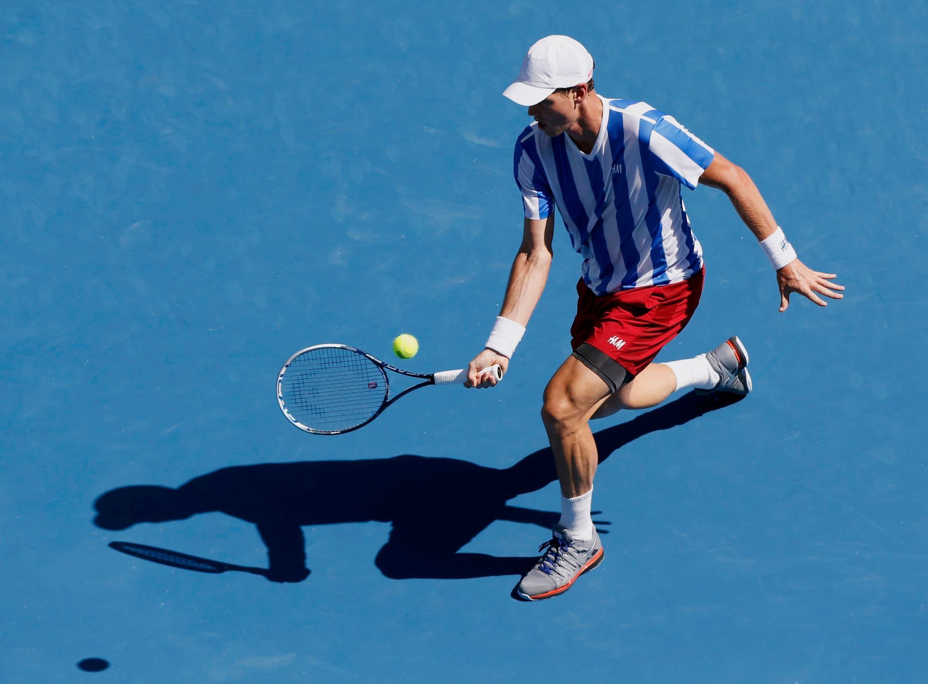 Tomas Berdych of the Czech Republic hits a return to Damir Dzumhur of Bosnia and Herzegovina during their men's singles match at the Australian Open 2014 tennis tournament in Melbourne