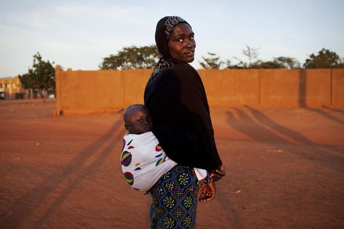 Douentza resident Kadjiatou poses for a picture with her child on her back in the recently liberated town, Mali January 29, 2013. REUTERS/Joe Penney (MALI - Tags: CIVIL UNREST POLITICS CONFLICT) Published: Led. 29, 2013, 9:22 odp.