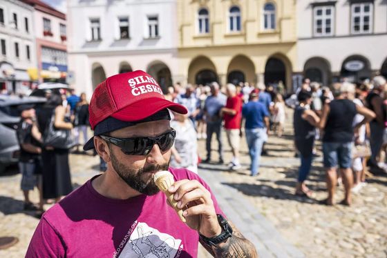 Neuniformovaný policista s Babišovou předvolební kšiltovkou.