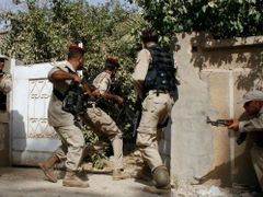 Členové milic Sahwa vnikají do jednoho z domů v Bagdádu