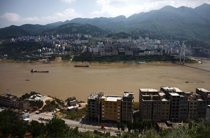 Ships sail on the Yangtze River in Badong, 100km (62 miles) from the Three Gorges dam in Hubei province August 7, 2012. China relocated 1.3 million people during the 17 years it took to complete the Three Gorges dam. Even after finishing the $59 billion project last month, the threat of landslides along the dam's banks will force tens of thousands to move again. It's a reminder of the social and environmental challenges that have dogged the world's largest hydroelectric project. While there has been little protest among residents who will be relocated a second time, the environmental fallout over other big investments in China has become a hot-button issue ahead of a leadership transition this year. Picture taken on August 7, 2012. To match story CHINA-THREEGORGES/ REUTERS/Carlos Barria (CHINA - Tags: POLITICS ENVIRONMENT BUSINESS ENERGY MARITIME) Published: Srp. 22, 2012, 8:23 odp.