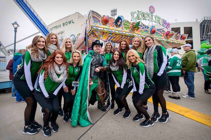 Jan 1, 2020; Dallas, Texas, USA; The Dallas Stars ice girls and Stars super fan Matthew Day pose for a photo before the 2020 Winter Classic hockey game at the Cotton Bowl