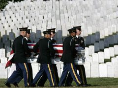 Američtí vojáci pohřbívají na čestném vojenském hřbitově v Arlingtonu kolegy, kteří padli v Iráku.