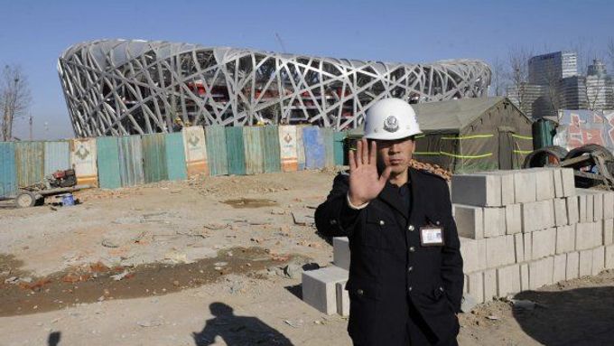 Čínský policista střeží olympijské staveniště.