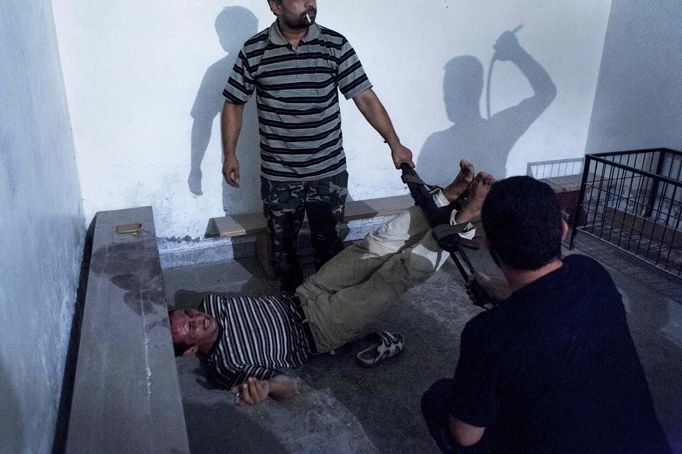 ATTENTION EDITORS - PICTURE 2 OF 18 OF THE WINNERS OF THE 56th WORLD PRESS PHOTO CONTEST 2013 Emin Ozmen of Turkey has won the second prize in the Spot News Single category of the World Press Photo Contest 2013 with this picture of Syrian opposition fighters interrogating and torturing an informant in Aleppo taken on July 31, 2012 and distributed by the World Press Photo Foundation February 15, 2013. The prize-winning entries of the World Press Photo Contest 2013, the world's largest annual press photography contest, were announced today, February 15, 2013. REUTERS/Emin Ozmen/World Press Photo/Handout (SYRIA - Tags: POLITICS CIVIL UNREST MEDIA SOCIETY) ATTENTION EDITORS - THIS IMAGE WAS PROVIDED BY A THIRD PARTY. FOR EDITORIAL USE ONLY. NOT FOR SALE FOR MARKETING OR ADVERTISING CAMPAIGNS. THIS PICTURE IS DISTRIBUTED EXACTLY AS RECEIVED BY REUTERS, AS A SERVICE TO CLIENTS. NO SALES. NO ARCHIVES. Published: Úno. 15, 2013, 10:02 dop.