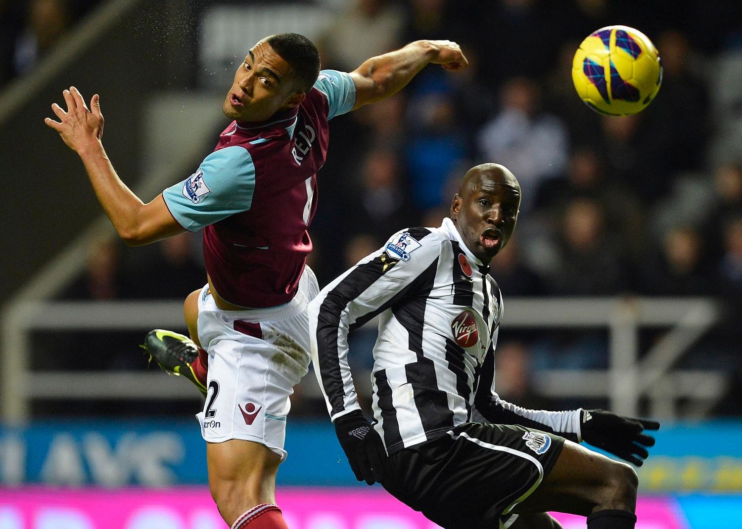 Fotbalista West Hamu Demba Ba se sráží s Winstonem Reidem z Newcastlu v utkání anglické Premier League 2012/13.