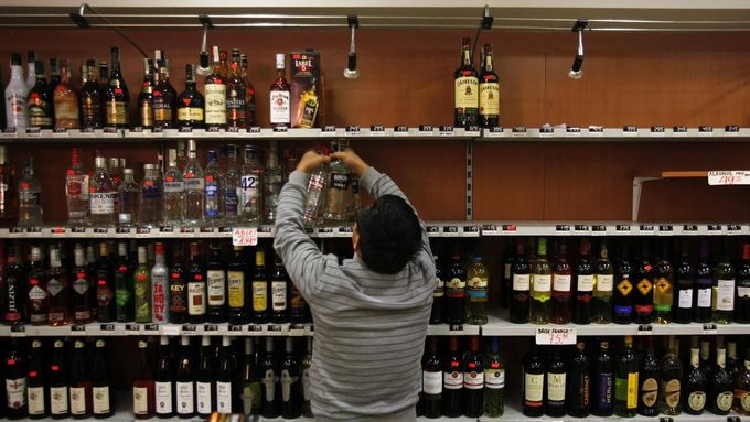 Odklízení tvrdého alkoholu z obchodu v Praze, jak jej nasnímala agentura Reuters.