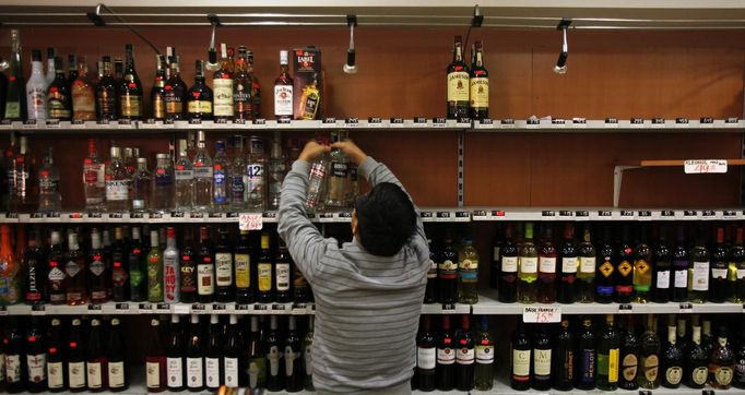 Odklízení tvrdého alkoholu z obchodu v Praze, jak jej nasnímala agentura Reuters.