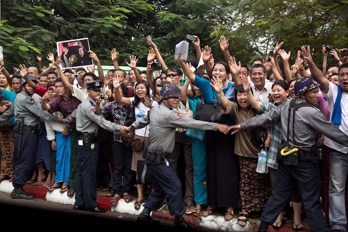 Nov. 19, 2012 "Police hold back the crowd as residents line the streets of the motorcade route to welcome the first sitting President of the United States to visit Burma. This photograph was taken through the bullet-proof window of the vehicle just in front of the President's. I love that three of the police are also trying to sneak a glimpse, one with a smile on his face."