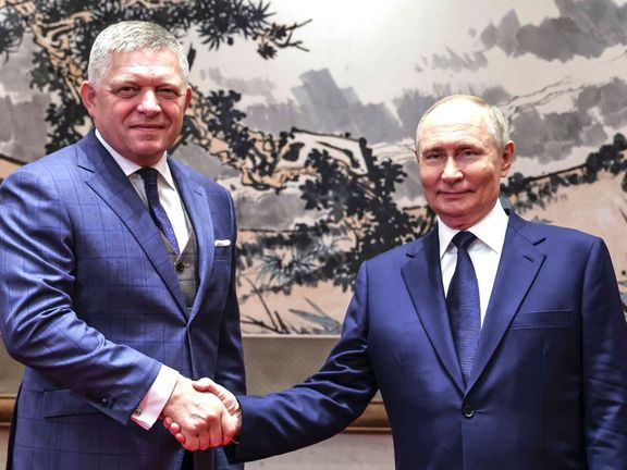 Ruský prezident Vladimir Putin (vpravo) a slovenský premiér Robert Fico si podávají ruce během svého setkání v Diaoyutai státní rezidenci v Pekingu.