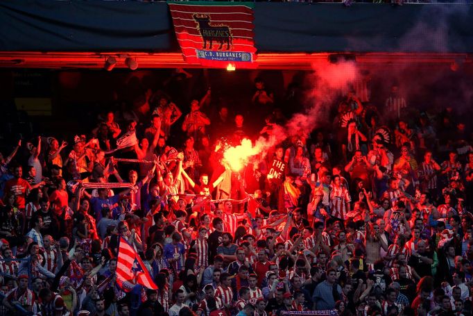 Atletico Madrid supporters light a flare as they celebrate their first goal during their Champions League final soccer match against Real Madrid, at a fan zone at Vicente