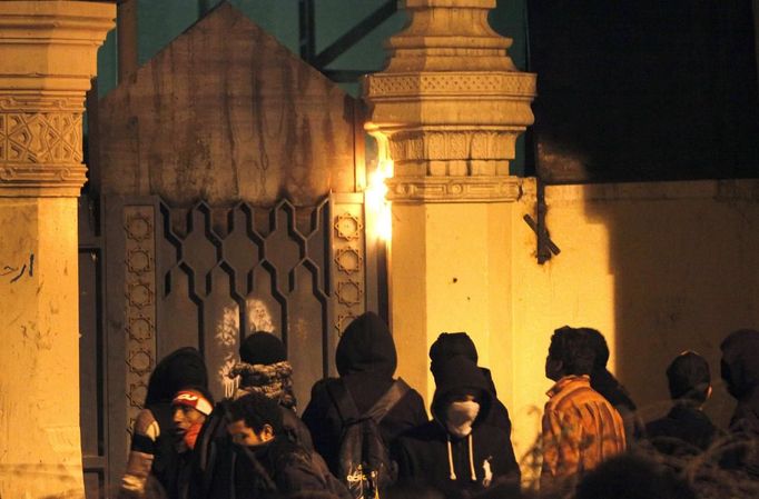 Protesters opposing Egyptian President Mohamed Mursi and the Muslim Brotherhood try to set a wall near one of the gates of the Presidential Palace on fire, as they chant anti-government slogans, in Cairo February 11, 2013. Protesters demanding the departure of Mursi clashed with police outside his palace on Monday on the second anniversary of the overthrow of veteran autocrat Hosni Mubarak. Dozens of youths threw rocks at the Ettihadiya palace after a peaceful march by thousands of demonstrators who accused Mursi's conservative Muslim Brotherhood of hijacking Egypt's democratic revolution and seeking to monopolise power. REUTERS/Asmaa Waguih (EGYPT - Tags: POLITICS CIVIL UNREST) Published: Úno. 11, 2013, 8:50 odp.