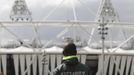 A security guard walks towards the Olympic Stadium in the London 2012 Olympic Park at Stratford in London July 13, 2012. Britain's air force will be on standby to shoot down any rogue aircraft over London from Saturday under tight new restrictions being enforced two weeks ahead of the Olympic Games. Security surrounding the Olympics has made the headlines this week after Britain was forced to deploy 3,500 extra troops to fill an embarrassing last-minute shortfall in private security staff.REUTERS/Luke MacGregor (BRITAIN - Tags: SPORT OLYMPICS MILITARY POLITICS) Published: Čec. 13, 2012, 2:52 odp.