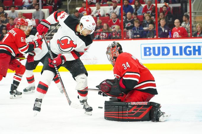 Brankář Caroliny Petr Mrázek čelí nájezdu Milese Wooda z New Jersey