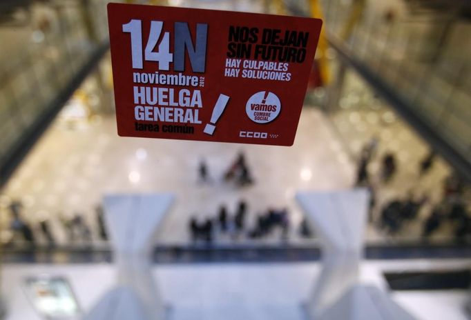 Passengers wait for their luggages after arriving at Madrid's Barajas airport, during a 24-hour nationwide general strike November 14, 2012. Spanish and Portuguese workers are staging the first coordinated general strike across the Iberian Peninsula on Wednesday, shutting transport, grounding flights and closing schools to protest against spending cuts and tax hikes. The Spanish words on the sticker reads, "14N General Strike. A common task. They leave us without future. There are culprits, there are solutions". REUTERS/Sergio Perez (SPAIN - Tags: POLITICS BUSINESS EMPLOYMENT CIVIL UNREST TRANSPORT) Published: Lis. 14, 2012, 9:11 dop.