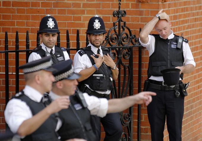 A police officer reacts to the heat of the day before a speech by Wikileaks founder Julian Assange at the Ecuador's embassy, where he is taking refuge in London August 19, 2012. REUTERS/Chris Helgren (BRITAIN - Tags: POLITICS CRIME LAW MEDIA) Published: Srp. 19, 2012, 5:26 odp.