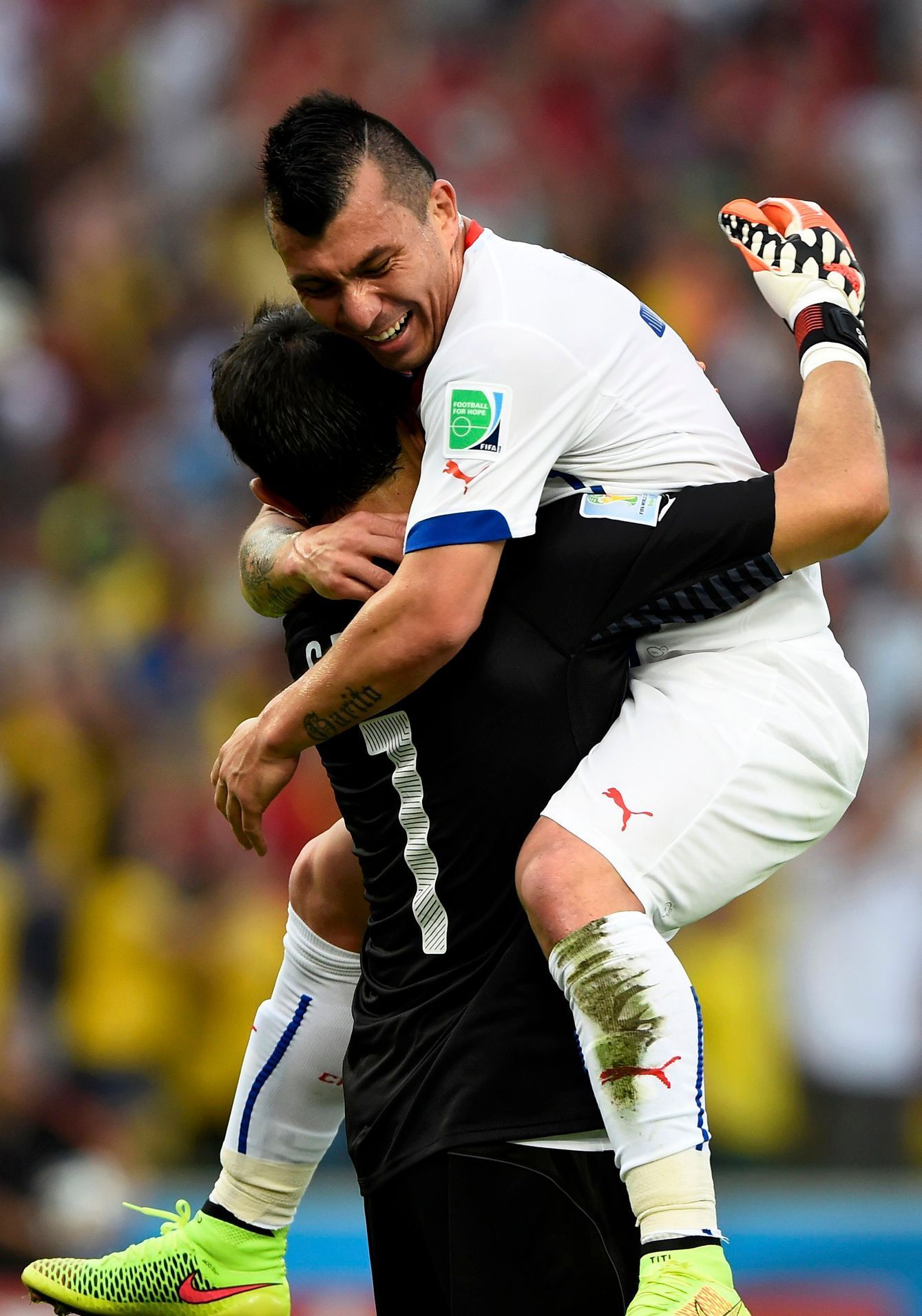 Chile's Medel hugs Bravo after the team scored their first goal against Spain during their 2014 World Cup Group B soccer match in Rio de Janeiro