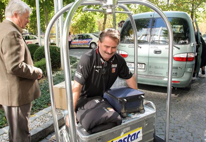 Kustod týmu John vykládá v Mnichově z autobusu bagáž